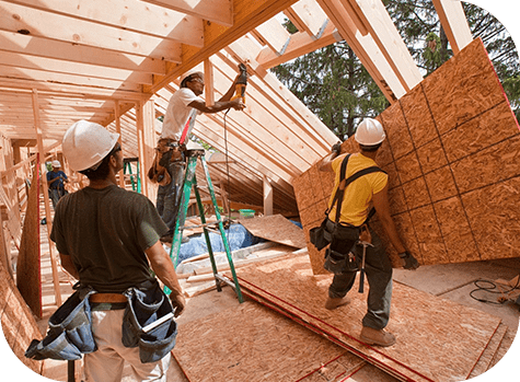 A group of men working on the roof of a house.