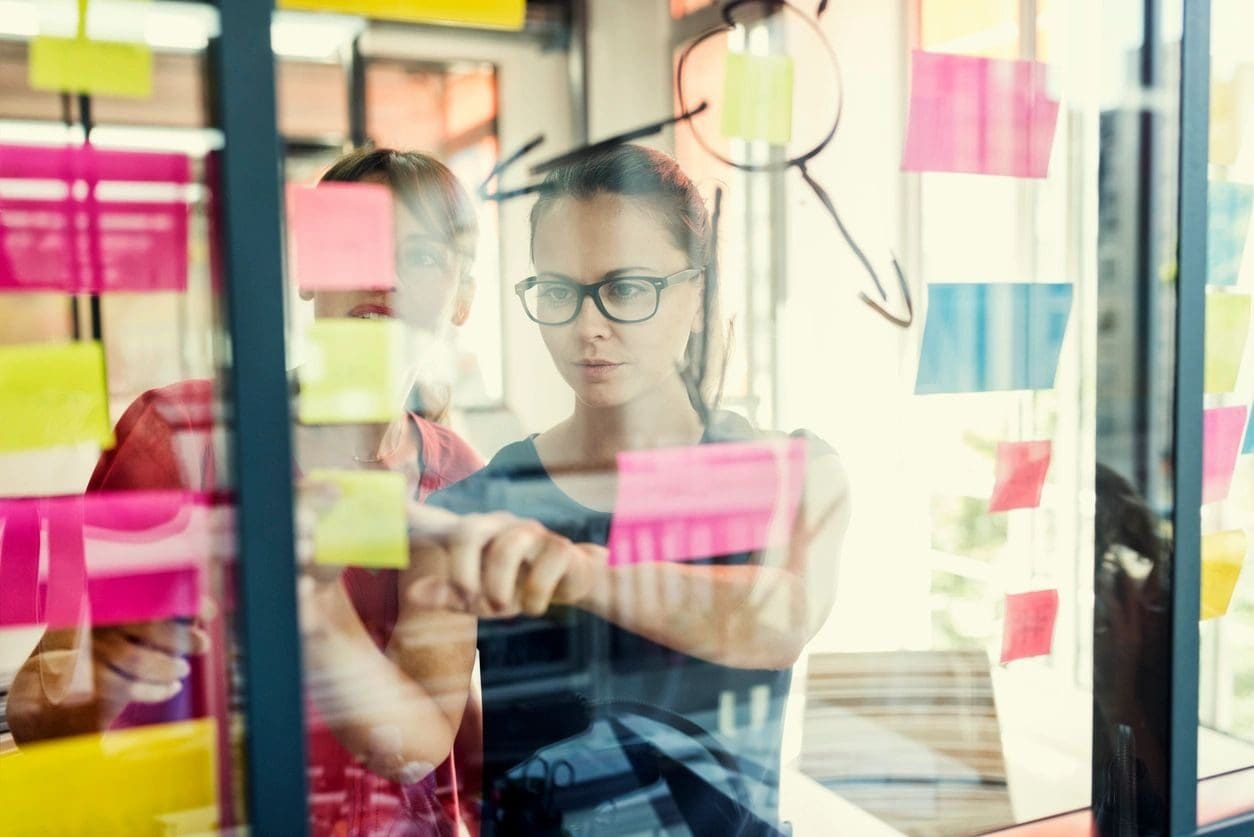 A woman looking through sticky notes on the window.