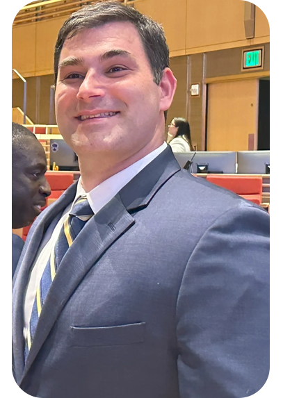 A man in a suit and tie smiling for the camera.